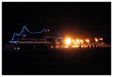 A huge playa barge made from school bus and neon lights stops to watch the Burn Nation fire display.